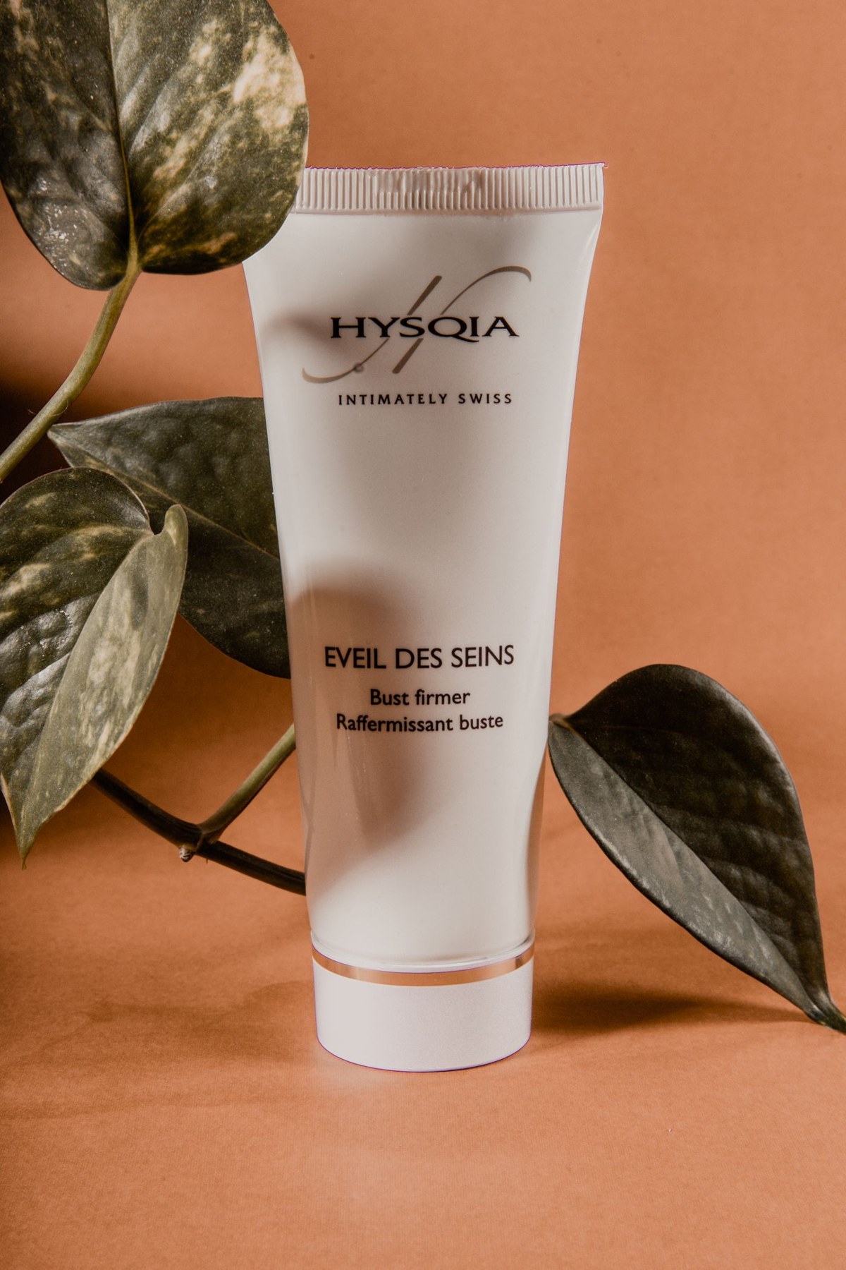 A moisturiser tube resting against a neutral backdrop