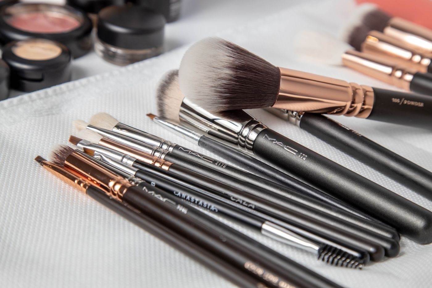 Makeup brushes laid out on a white cloth