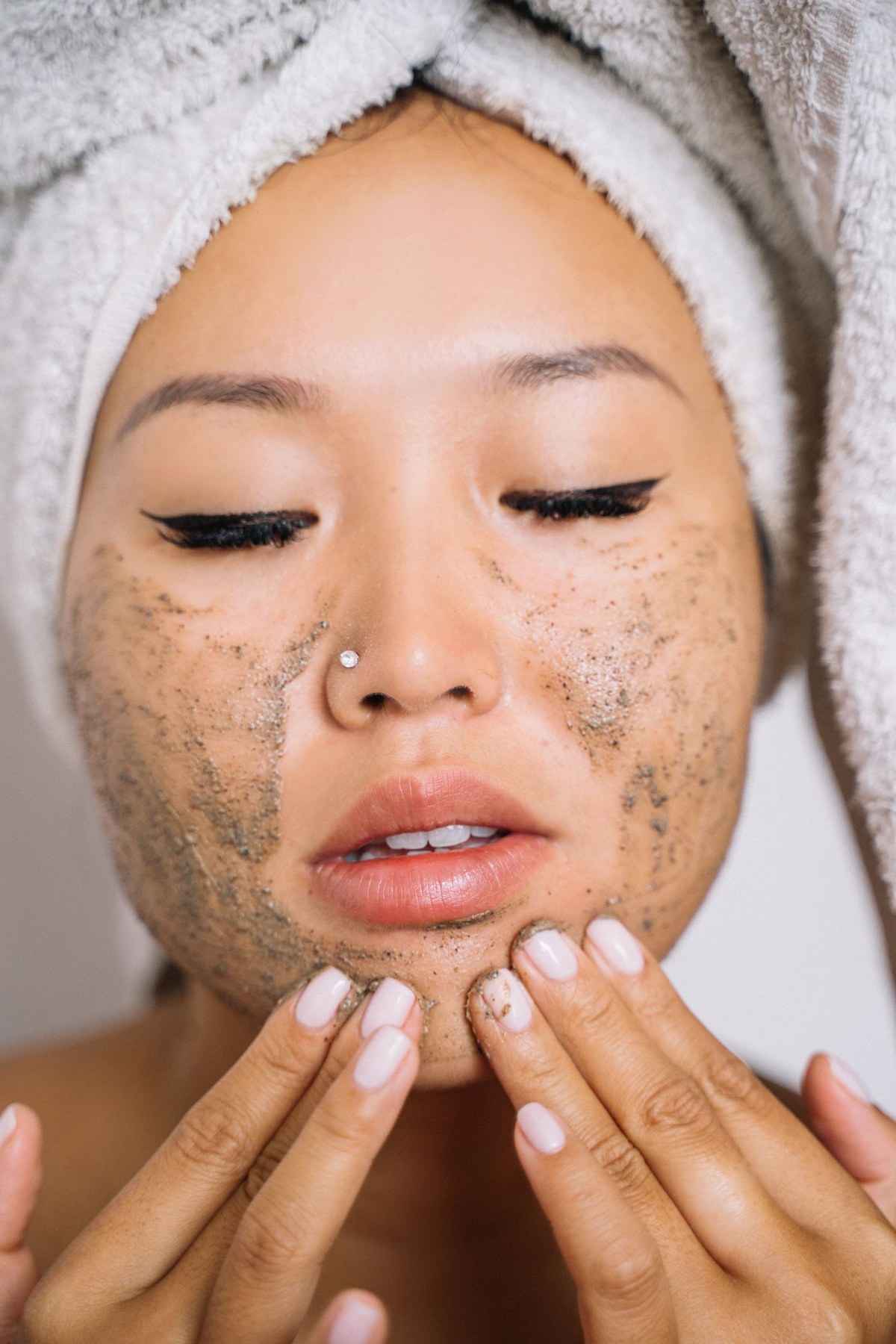 A woman applies facial scrub