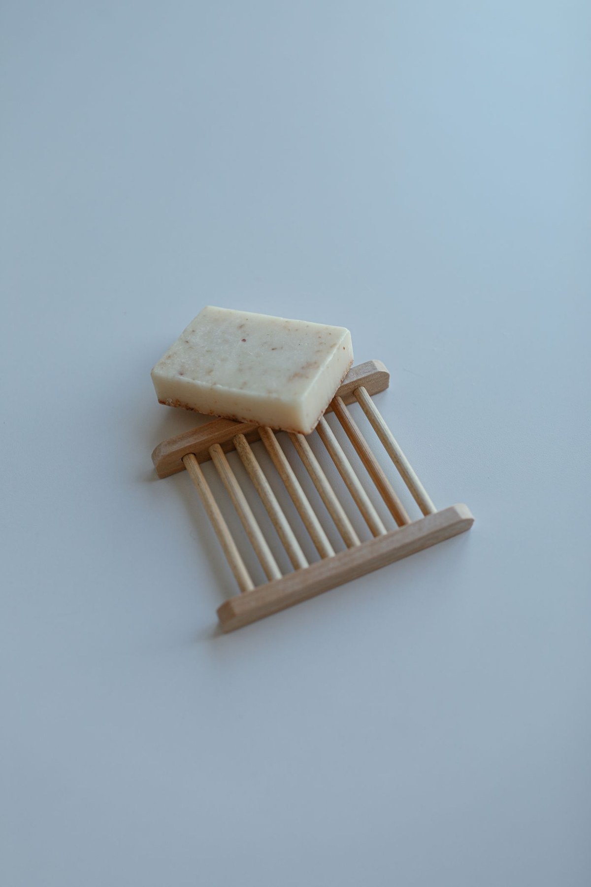 A bar of soap resting on a slatted wooden dish