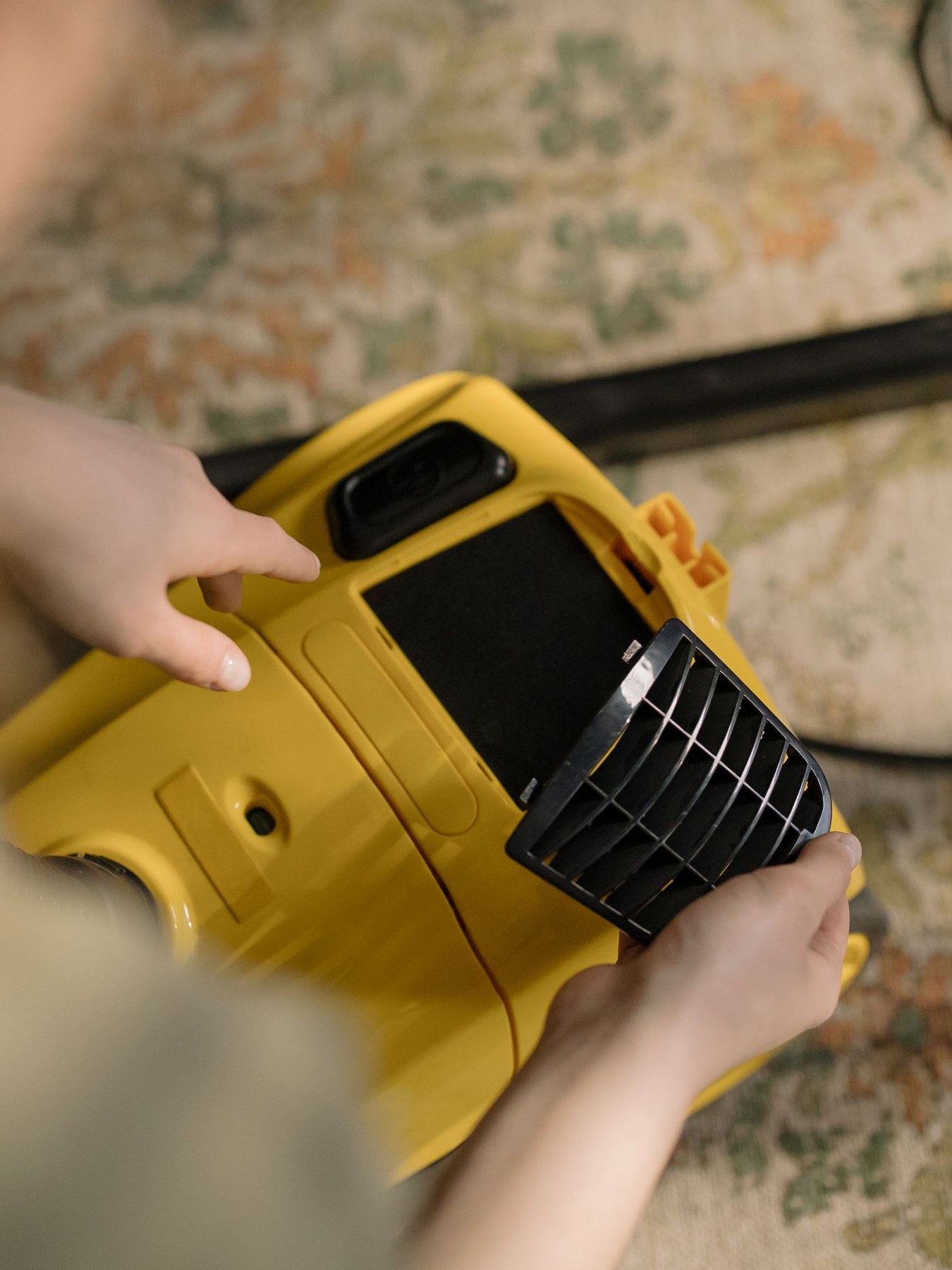 A vacuum cleaner opened to expose its filter