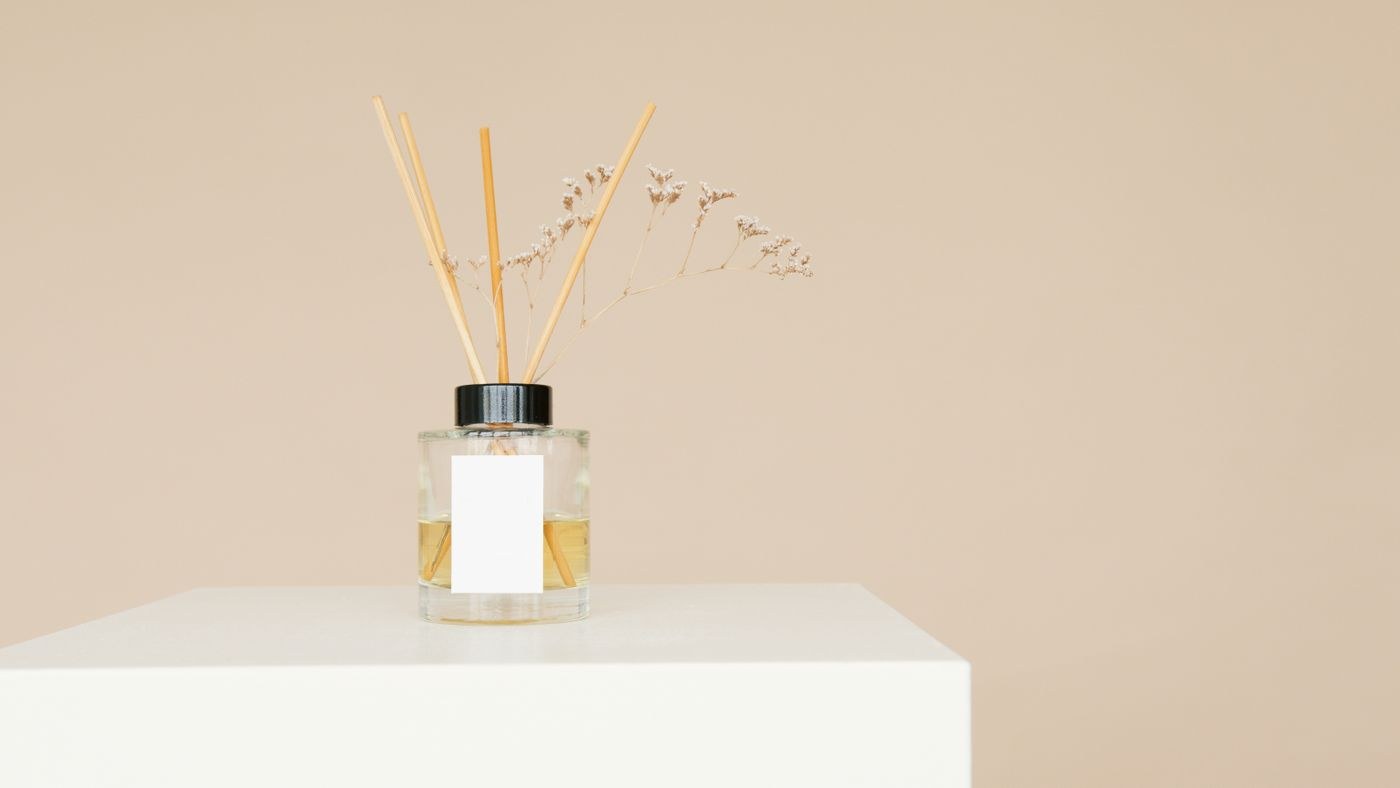 A reed diffuser bottle with sticks on a small display surface